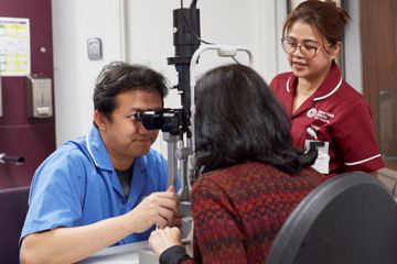 A nurse performs an eye exam