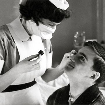 A historic picture of a patient receiving eye drops