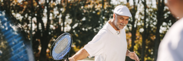 A senior man playing tennis.