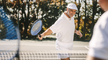 A senior man playing tennis.