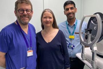 Moorfields team members and a patient next to a machine