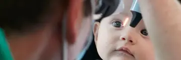 Baby being examined by eye care expert