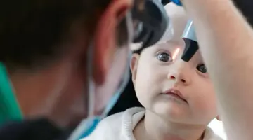 Baby being examined by eye care expert