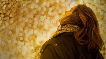 A young woman looking up at the illumination