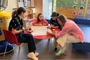 Group of people of different ages sitting around a table and writing on a piece of paper in RDCEC