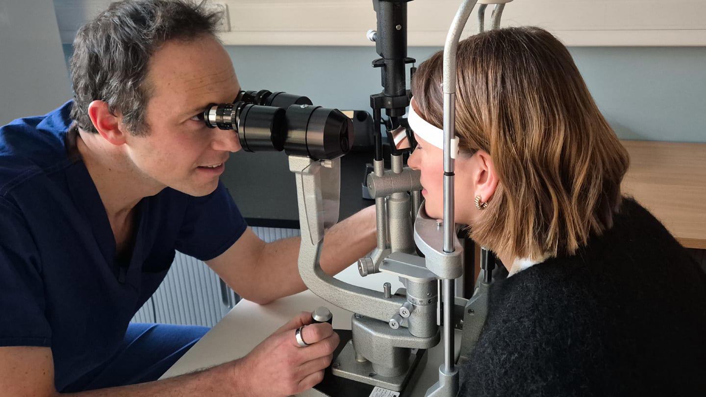 Ophthalmologist looking into patient eyes