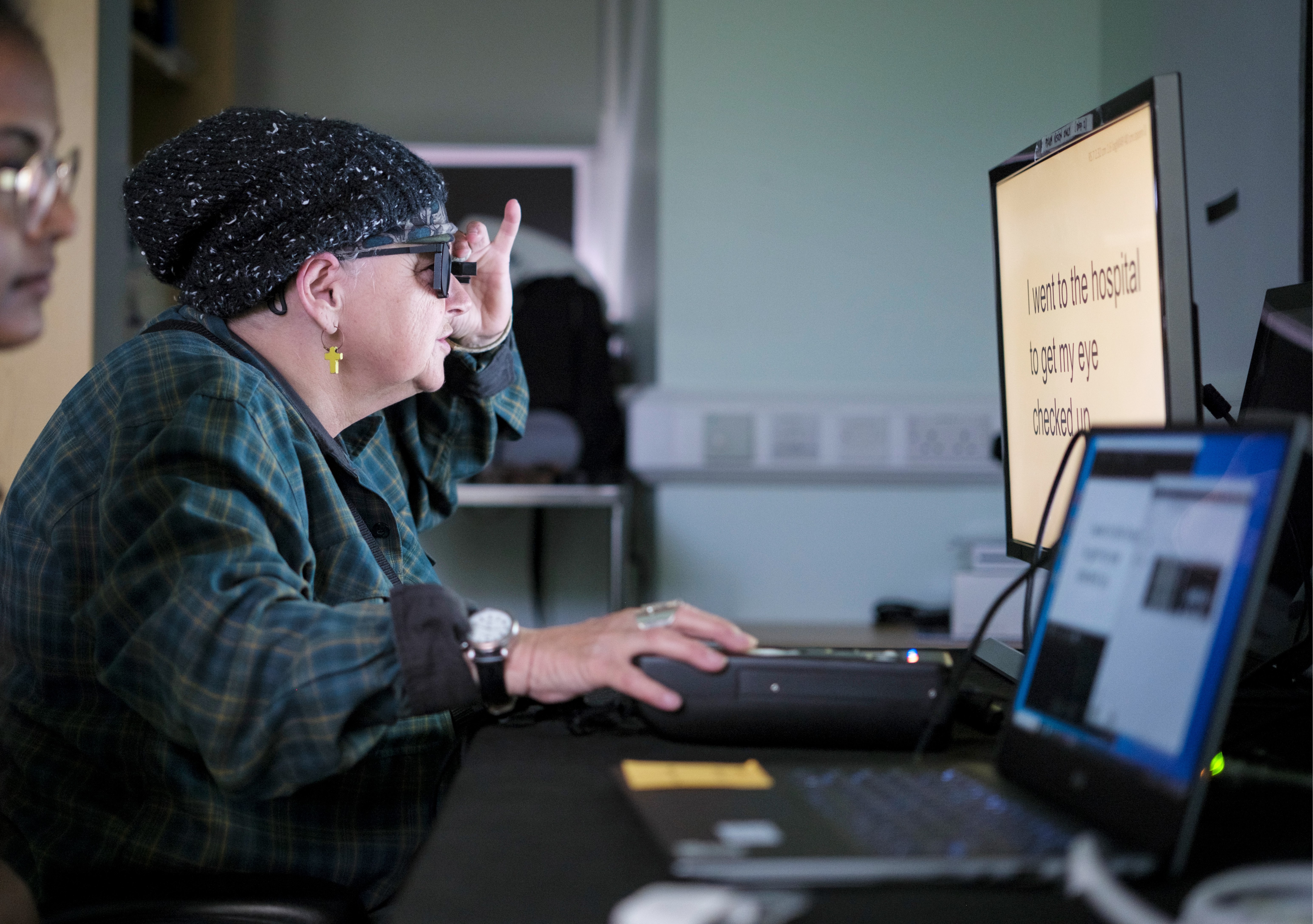 Patient being trained after eye implant surgery, looking at a computer wearing glasses