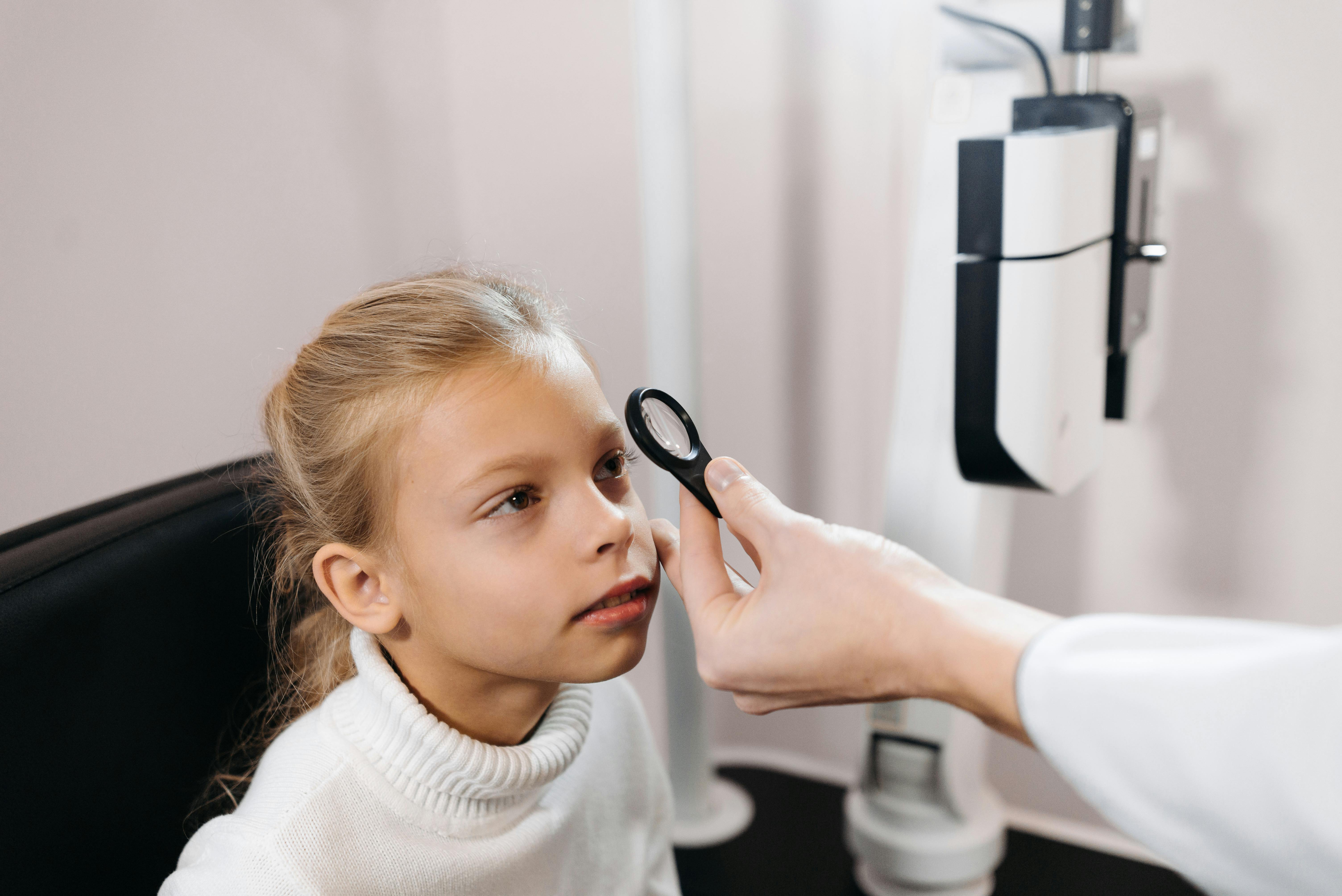 Child looking into handheld lens during an eye examination