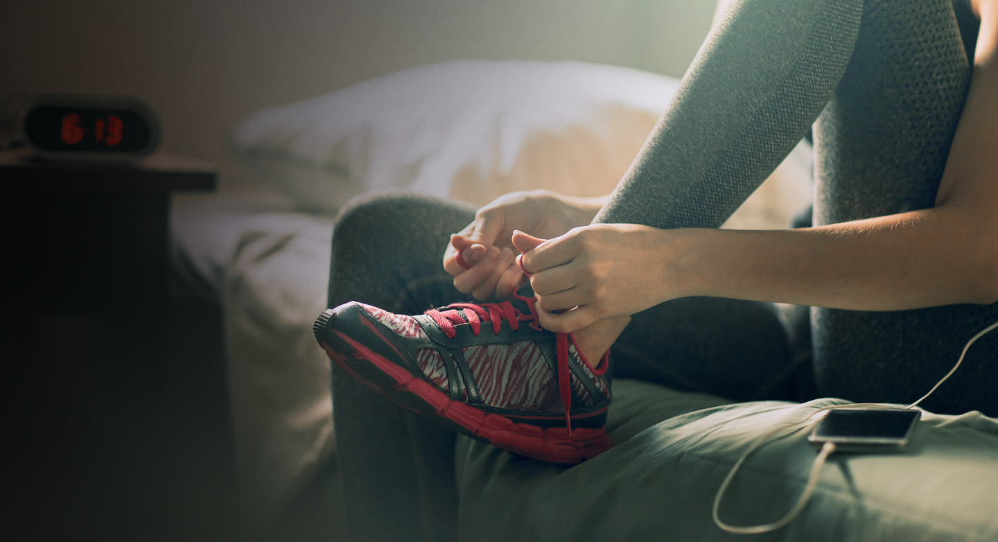 A young woman doing up her shoelaces