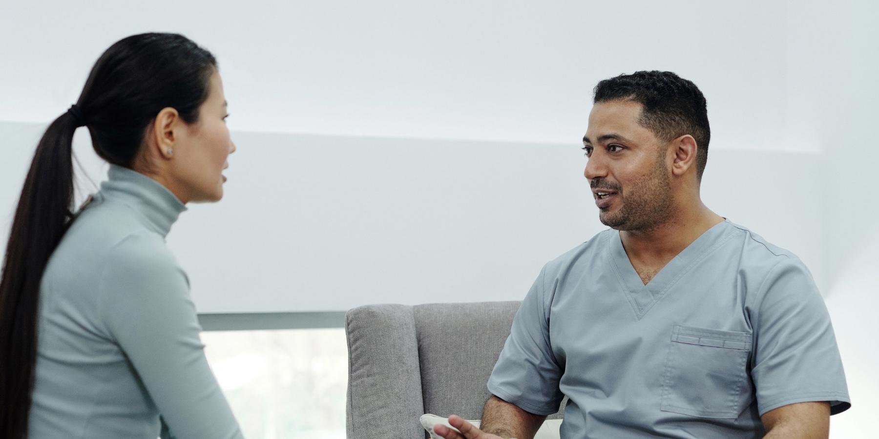 Two people sitting together and speaking with each other