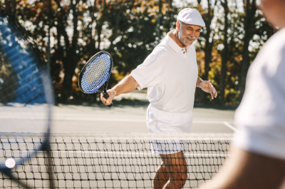 A mature man playing tennis