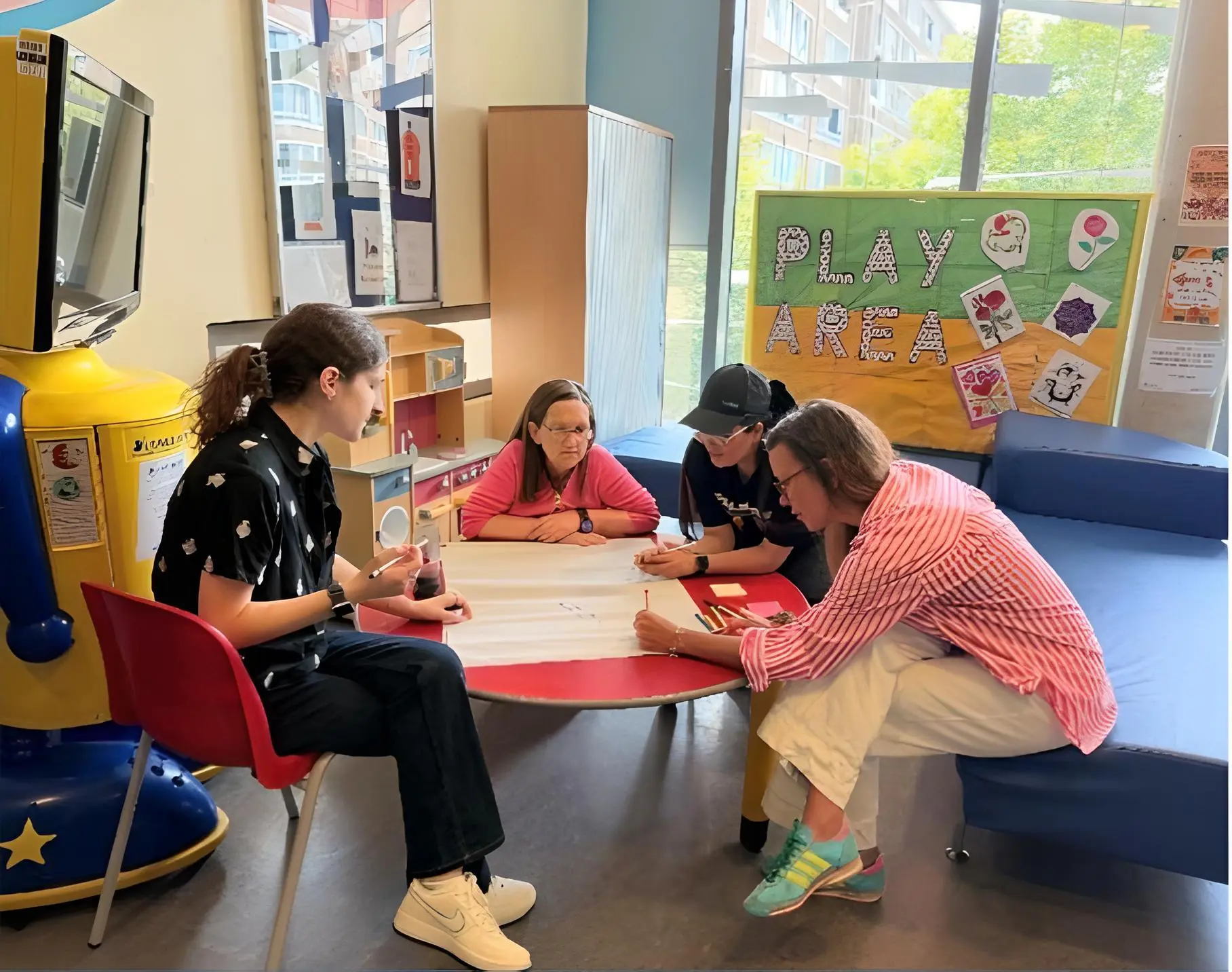 Group of people of different ages sitting around a table and writing on a piece of paper in RDCEC