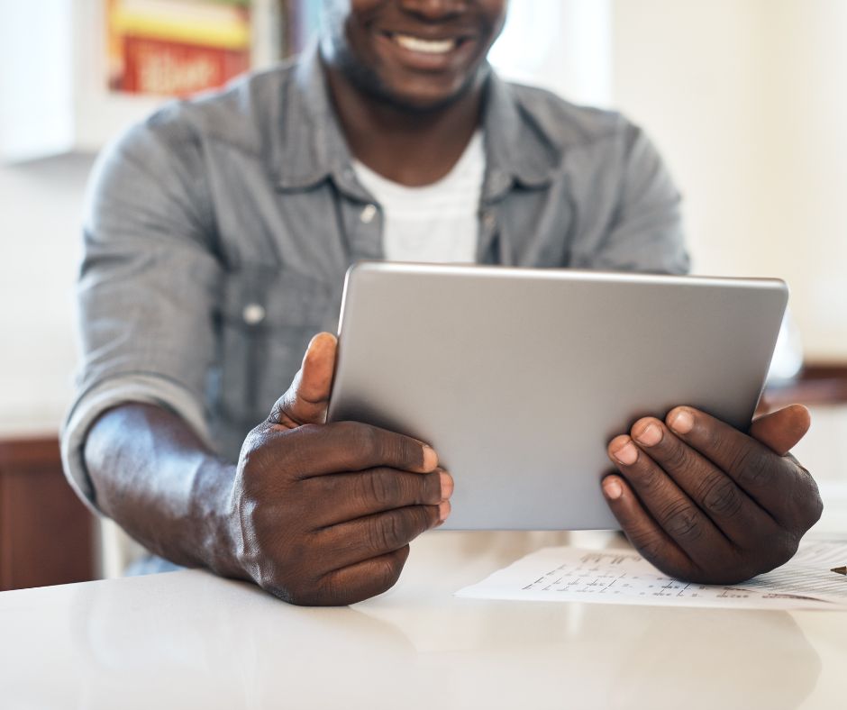 A man holding his tablet and smiling
